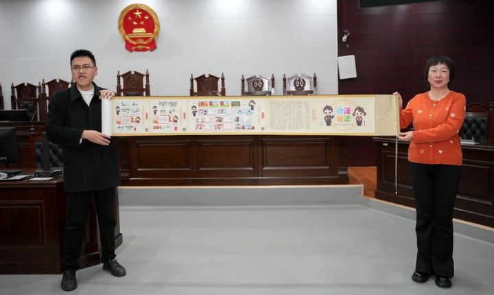 3、法官將《動(dòng)漫說(shuō)法》漫畫(huà)卷軸作為禮物贈(zèng)送給師生。