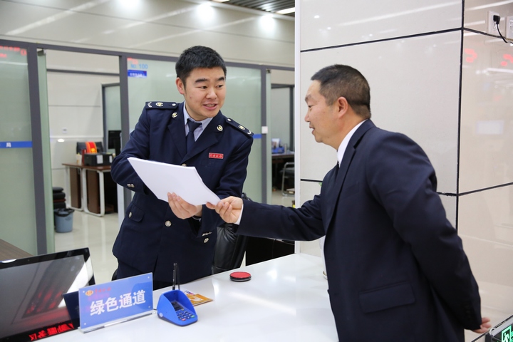 窗口人員為前來辦理契稅申報繳納的納稅人解讀契稅新政。鄭婷攝