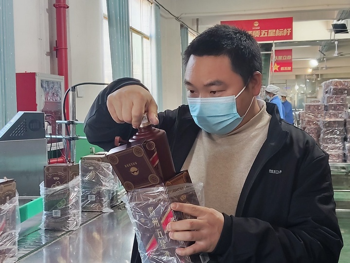 4、五星酒業(yè)集團(tuán)茅臺(tái)鎮(zhèn)五星酒廠包裝車間主任李明付在檢查產(chǎn)品。