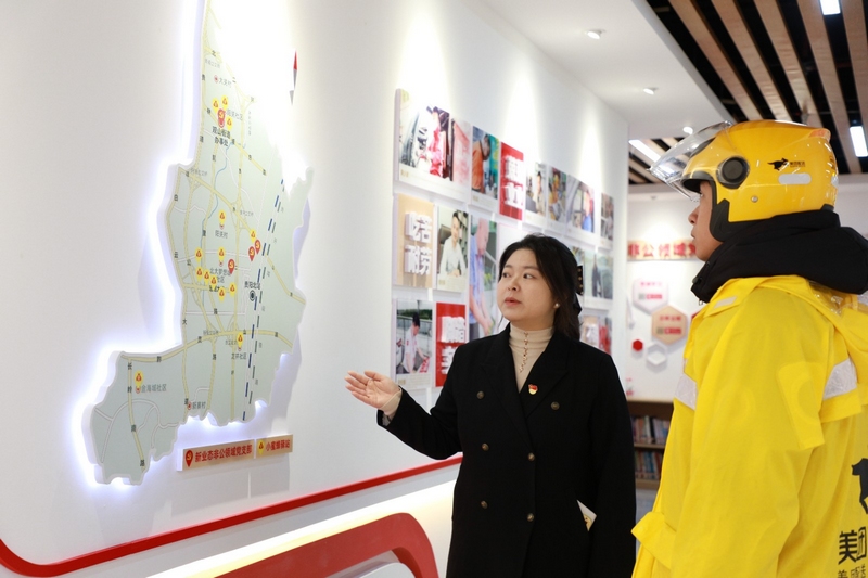 王涵向外賣(mài)小哥介紹轄區(qū)“小蜜蜂驛站”的分布情況
