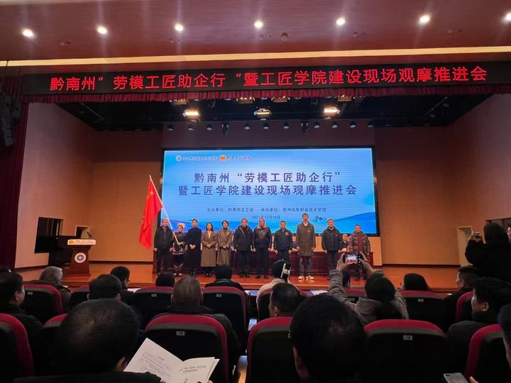 2 圖為州人大常委會副主任、州總工會主席朱勁松為黔南州“勞模工匠助企行”服務(wù)隊(duì)授旗。