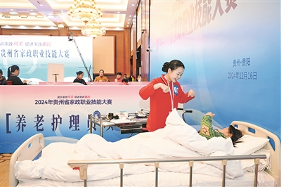 圖為養(yǎng)老護理員競賽項目中，選手耐心與老人溝通。