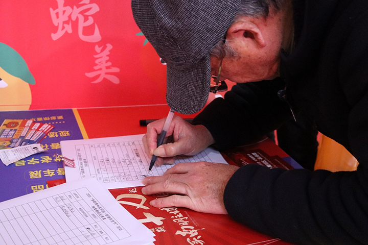 市民朋友正在消費(fèi)抽獎(jiǎng)優(yōu)惠登記。李宜桐攝