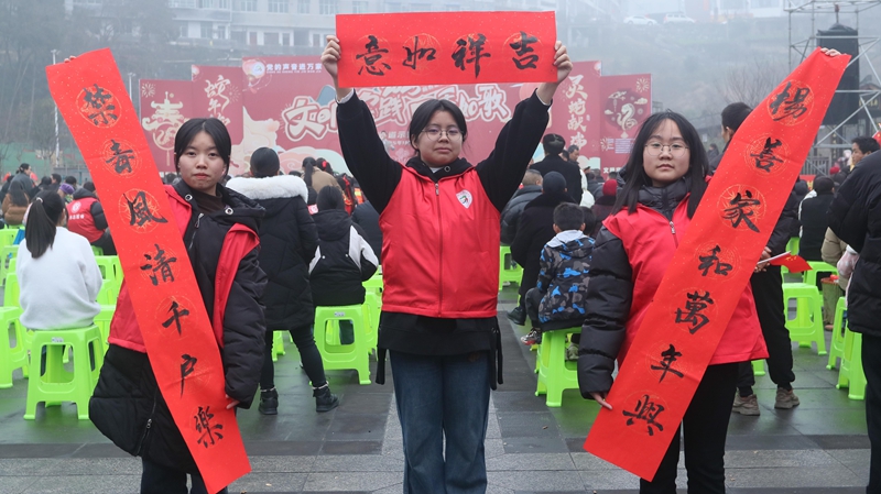 現(xiàn)場(chǎng)工作人員展示寫(xiě)好的春聯(lián)（習(xí)水縣融媒體中心供圖）.jpg
