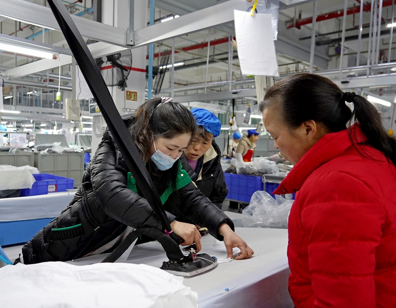 2025年2月7日，位于貴州省畢節(jié)市納雍縣工業(yè)園區(qū)的畢節(jié)市晶煌制衣有限公司生產(chǎn)車間，車間負責人在給新員工作崗前培訓。 楊 英 攝.jpg