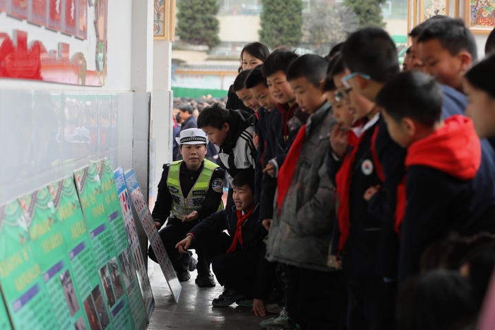 圖為：2025年2月17日，雷山縣公安局交警大隊輔警向學生講解宣傳展板1.JPG