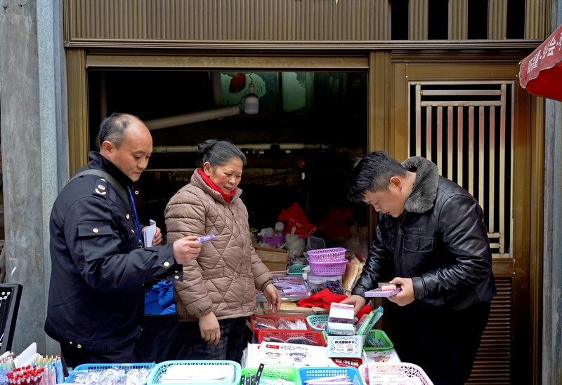2025年2月17日，貴州省畢節(jié)市納雍縣第一小學(xué)旁，檢查組在查看校園周邊攤點(diǎn)售賣物品。楊英攝