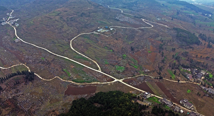 航拍貴州省黔西市鐵石苗族彝族鄉(xiāng)鐵盔山村的機耕道與村莊、山巒、田地構成一幅生機盎然的田園畫卷。 熊軍萬攝