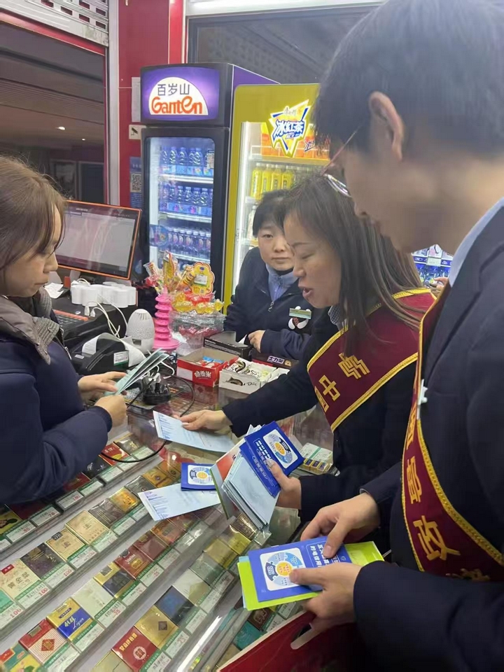 工作人員向北站商戶宣傳反詐、反假幣知識。