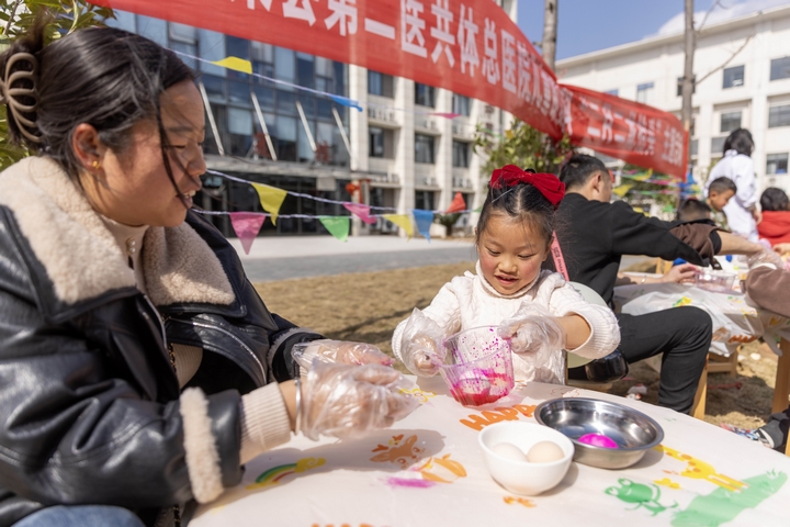 2025年2月28日，貴州省黔東南苗族侗族自治州施秉縣第二醫(yī)共體總醫(yī)院兒童康復(fù)科，家長(zhǎng)在指導(dǎo)孩子染紅蛋。（磨桂賓 攝） (2).jpg