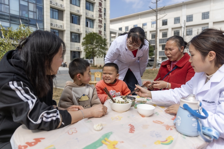 2025年2月28日，貴州省黔東南苗族侗族自治州施秉縣第二醫(yī)共體總醫(yī)院兒童康復(fù)科護(hù)士與家長(zhǎng)一起指導(dǎo)孩子包餃子。（磨桂賓 攝） (3).jpg