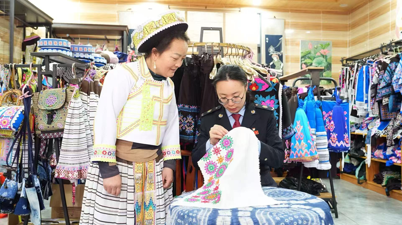 圖為稅務工作人員體驗少數(shù)民族刺繡工藝。