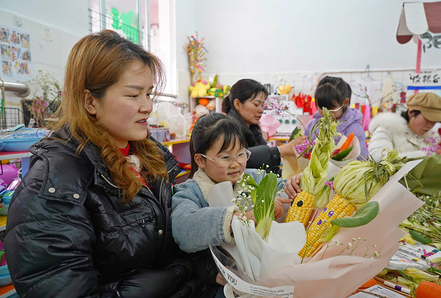 2025年3月6日，貴州省畢節(jié)市納雍縣龍場鎮(zhèn)中心幼兒園“溫情三八·感恩有您”活動現(xiàn)場，家長和孩子們一起做手工。  楊  英 攝