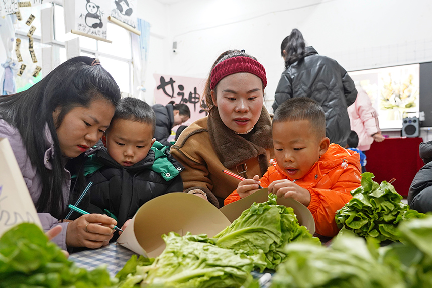 2025年3月6日，貴州省畢節(jié)市納雍縣龍場鎮(zhèn)中心幼兒園“溫情三八·感恩有您”活動現(xiàn)場，家長和孩子們一起做手工。 楊 英 攝
