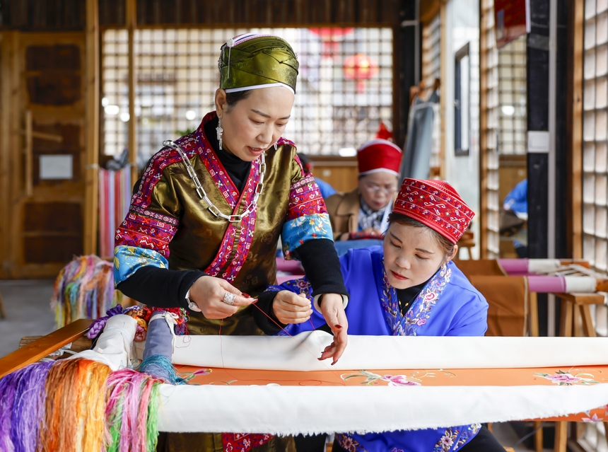 龍祿穎（左）在手工刺繡車間指導公司員工刺繡。