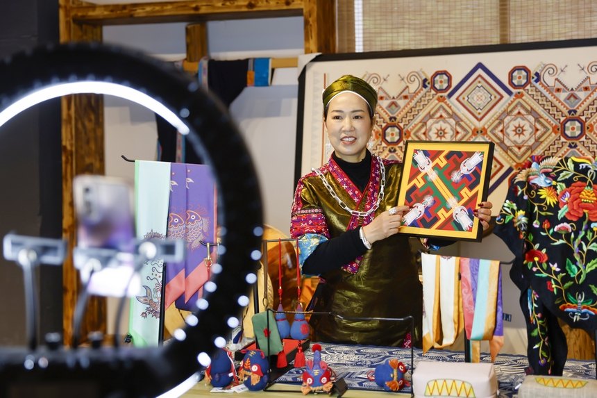 龍祿穎在公司的鄉(xiāng)村振興直播間推介苗繡文創(chuàng)產(chǎn)品。