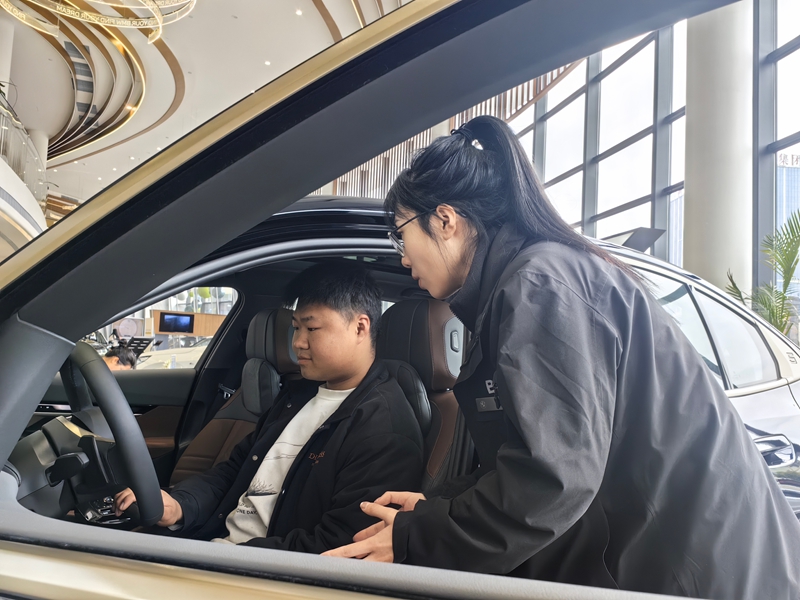 顧客正在汽車門店內(nèi)了解喜歡車的性能.jpg