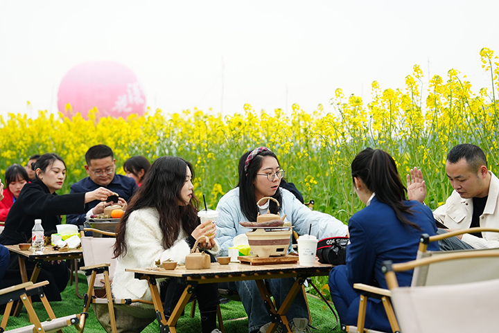 5、游客們?cè)诨ㄌ锱試鸂t煮茶。