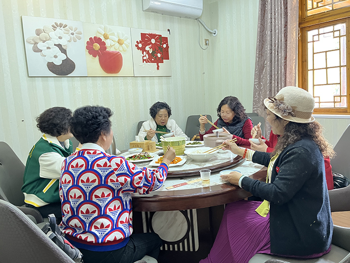 7、游客們?cè)诨ㄌ锱缘霓r(nóng)家樂(lè)就餐。