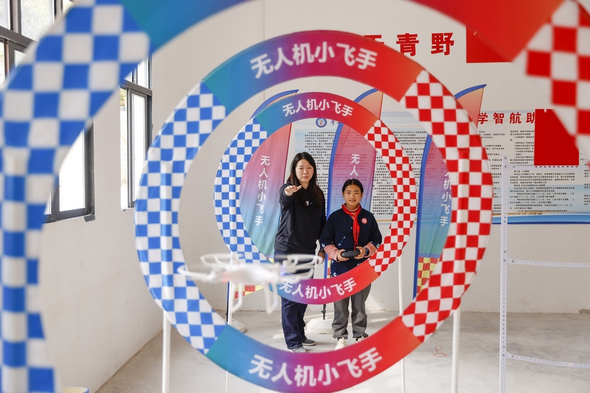 2025年4月10日，貴州省黔東南苗族侗族自治州施秉縣馬號鎮(zhèn)黃古小學(xué)，老師在指導(dǎo)學(xué)生練習(xí)操控?zé)o人機。