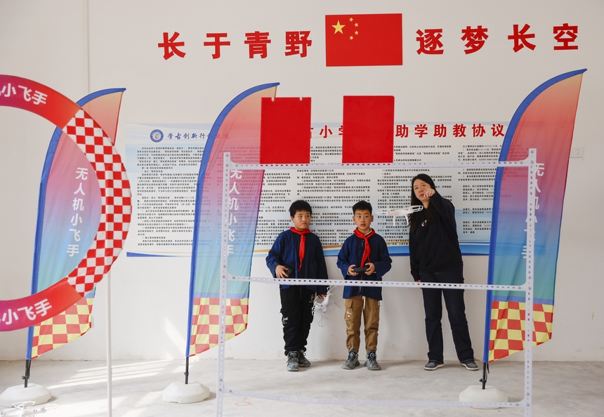 2025年4月10日，貴州省黔東南苗族侗族自治州施秉縣馬號(hào)鎮(zhèn)黃古小學(xué)，老師在指導(dǎo)學(xué)生練習(xí)操控?zé)o人機(jī)。
