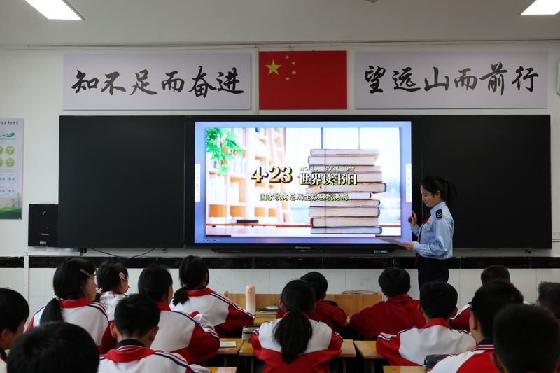 國家稅務(wù)總局金沙縣稅務(wù)局青年干部利用世界讀書日，與金沙縣第三中學(xué)聯(lián)合開展主題課堂。圖為稅務(wù)干部為青少年講解閱讀方法。朱泫粼