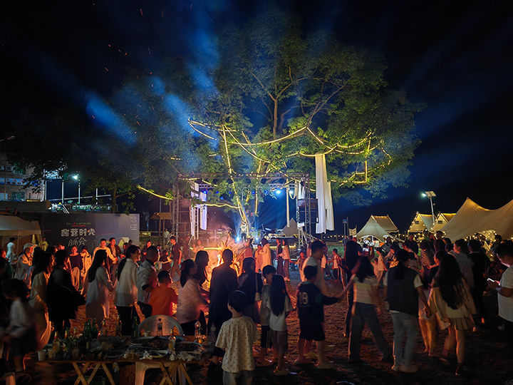 4、游客夜晚圍坐篝火旁，品嘗燒烤、仰望星空，沉浸于“時光音樂會”的民謠彈唱中。王琨榮攝