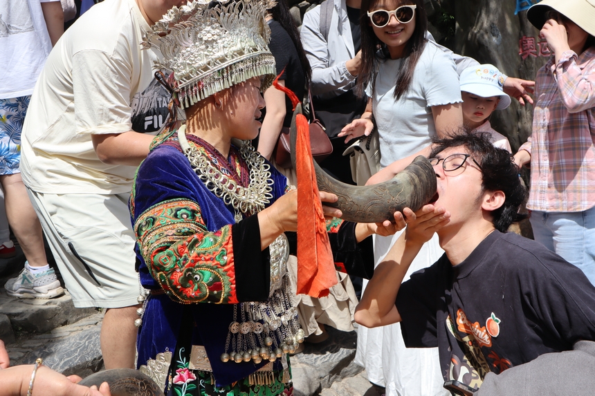 游客在郎德苗寨體驗(yàn)攔門(mén)酒。