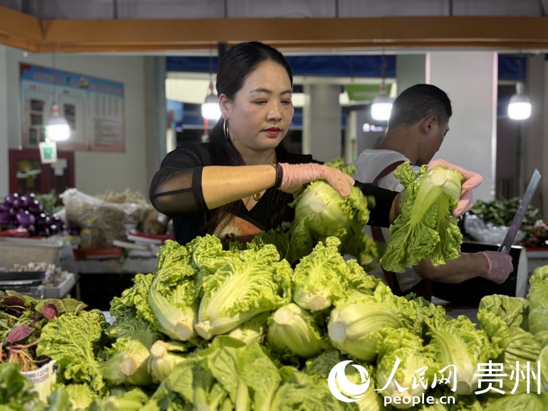 羅芬正在整理攤位上的蔬菜。人民網(wǎng)記者 高華攝