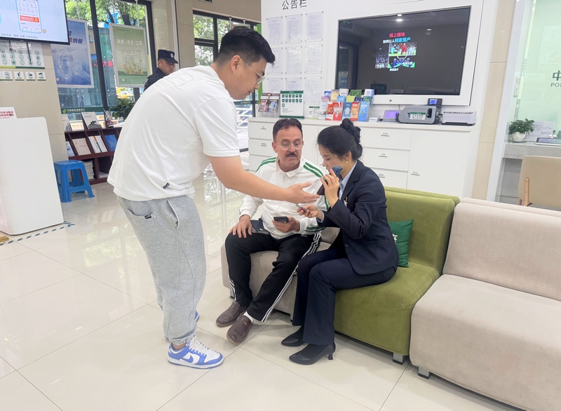 郵儲銀行黔東南州分行營業(yè)部業(yè)務(wù)人員借助中英文轉(zhuǎn)換APP與外籍客戶交流。