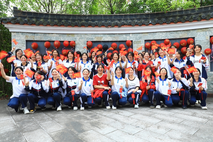 劍河民族中學(xué)高三學(xué)子手舉“金榜題名錦囊”在狀元亭旁合影。楊潔茹 攝