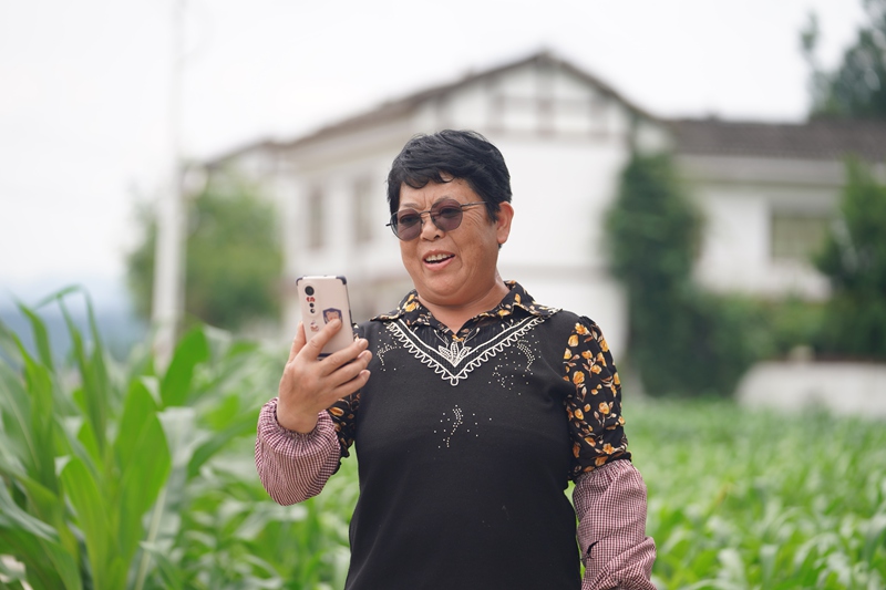 淹壩村村民鐘德容正與遠(yuǎn)在浙江務(wù)工的兒子通視頻。吳艷禹攝