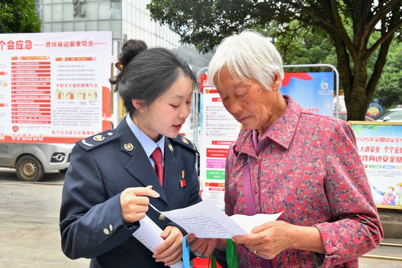 稅務(wù)人員向過往群眾宣傳非法集資的危害。張瑜顯攝