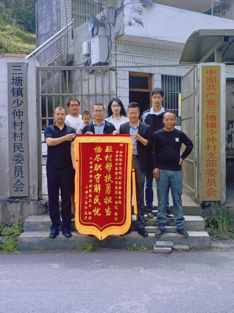 村委會為稅務(wù)干部送上錦旗并合影。村委會供圖