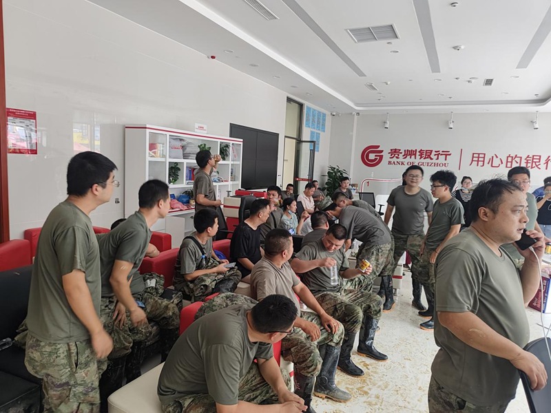 圖為應急救援隊在榕江支行營業(yè)大廳休息。