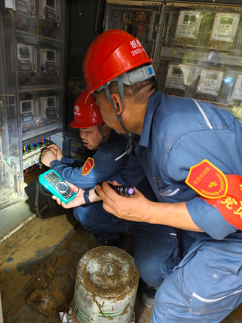 南方電網(wǎng)貴州畢節(jié)供電局黨員突擊隊(duì)隊(duì)員使用萬(wàn)用表檢查低壓線路是否具備送電條件。羅根攝