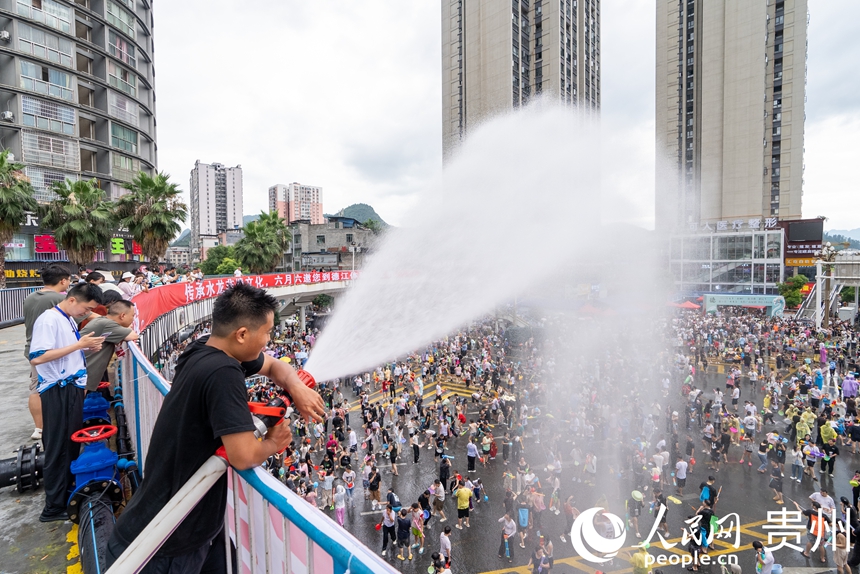 2025德江“水龍節(jié)”活動(dòng)現(xiàn)場(chǎng),工作人員為參加活動(dòng)的市民游客灑水助興。人民網(wǎng)記者 涂敏攝