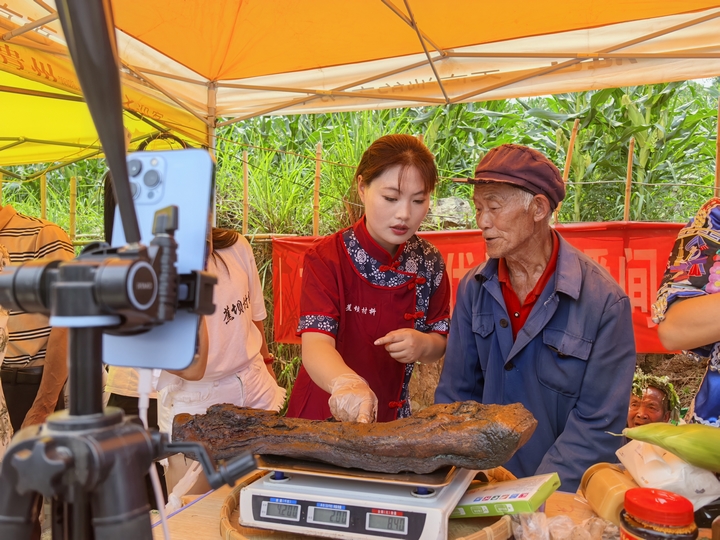 圖為“村抖”現(xiàn)場(chǎng)助農(nóng)主播直播銷售臘肉。鄒琴印攝.jpg