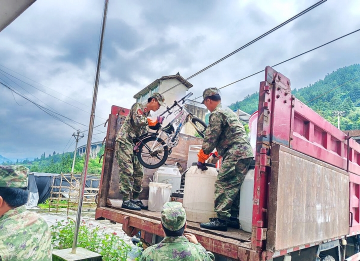 圖為，雷山縣武裝部派出的民兵應(yīng)急分隊(duì)在永樂(lè)鎮(zhèn)加支村忙著幫助受災(zāi)村民轉(zhuǎn)運(yùn)家具。.jpg