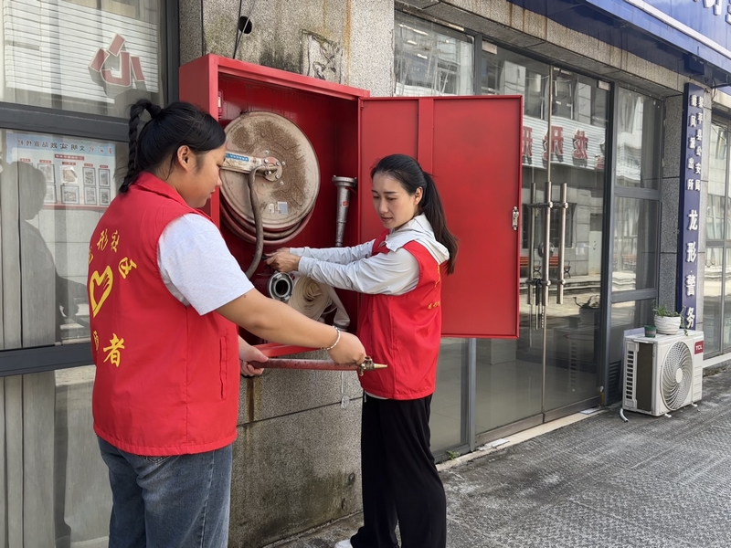 手把手教居民使用滅火器。