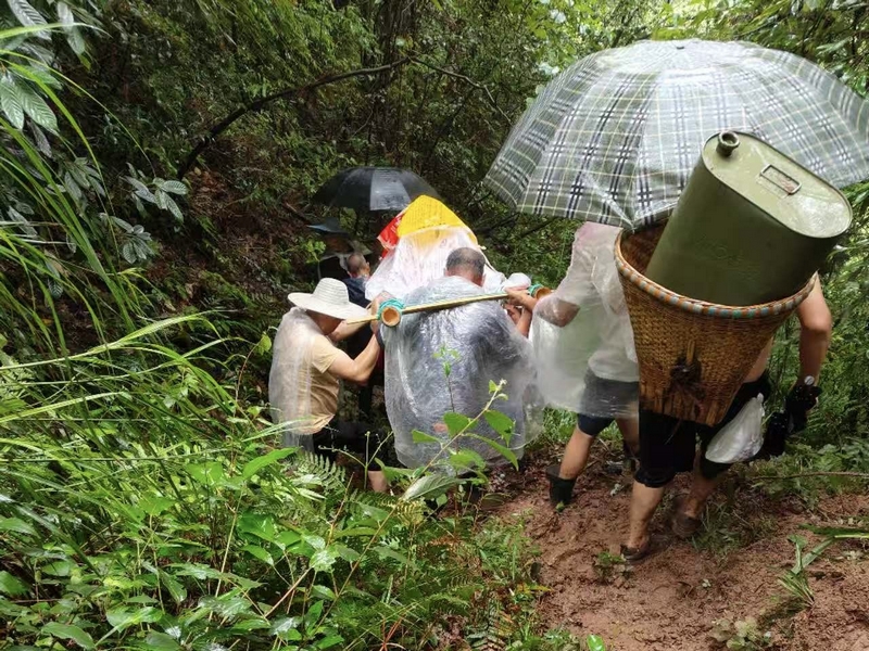 村民冒雨抬傷者穿行在濕滑山林間。習(xí)水縣融媒體中心供圖
